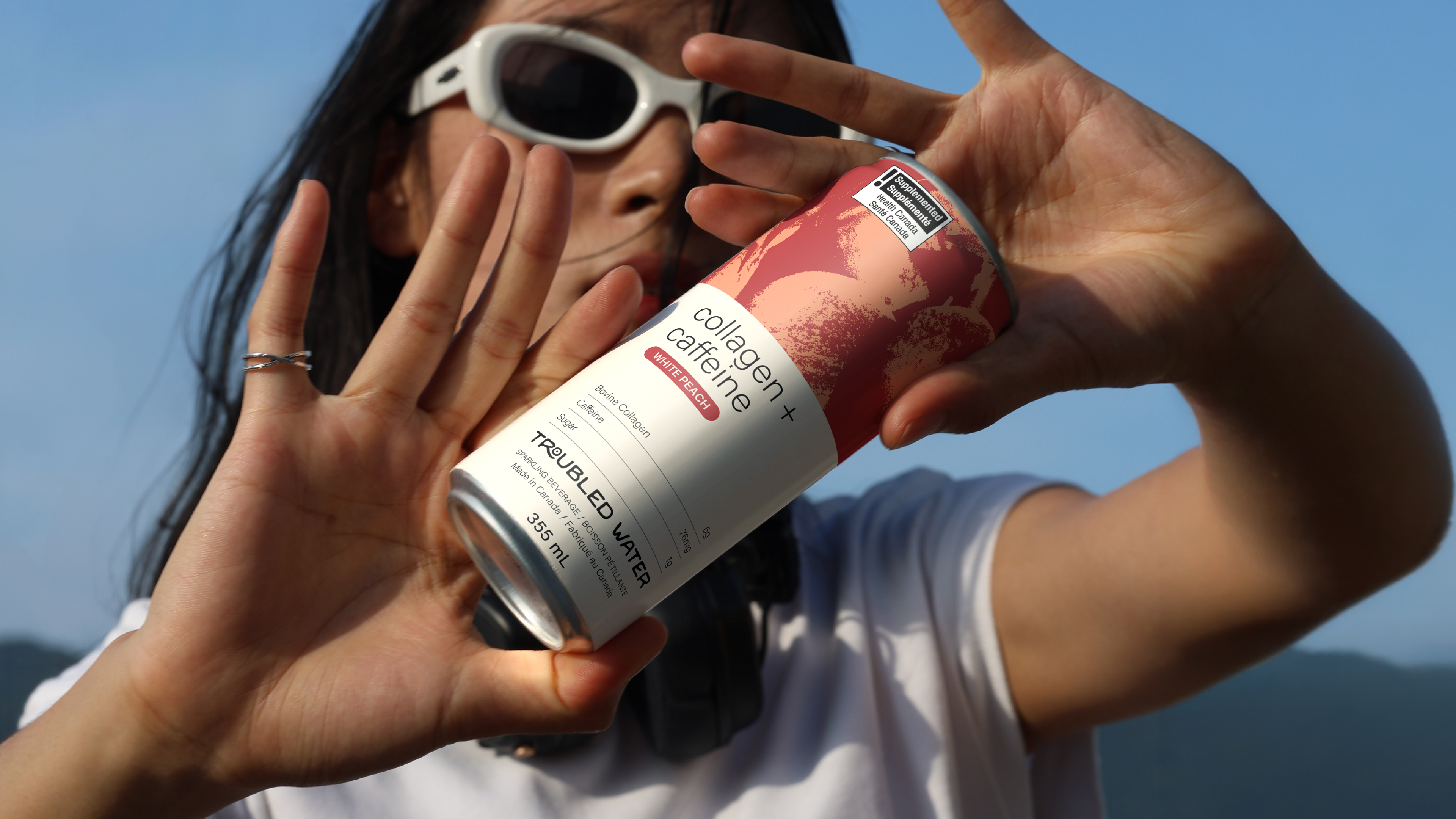 Person holding Troubled Water can