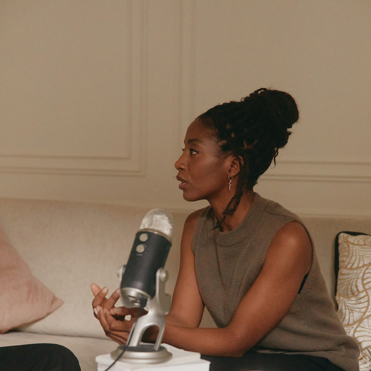Woman sitting in front of a microphone in an indoor setting